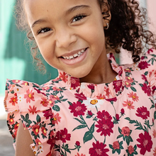 Load image into Gallery viewer, Fresh As A Daisy! A patch of wild daisies in shades of red, orange and white springs from a blush colored ground in our Pink Daisy Floral shown here on our Girls Jennifer Dress. This short sleeve flock favorite silhouette delights with its feminine ruffled neck and sleeves and fully gathered, two tiered skirt that spins like a dream. Invisible zipper. A silver thread woven throughout adds a touch of shimmer and shine. Match back to Little Sis in our Baby Girls Jennifer Bubble. 