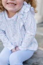 Load image into Gallery viewer, The Girls Favorite Things Legging Set from James & Lottie offers a charming combination of style and comfort. Featuring a pastel-colored Christmas tree print on a ruffled shoulder top paired with coordinating blue leggings, this set is perfect for toddlers and young girls. Its festive design and soft fabric make it ideal for holiday gatherings or everyday wear, ensuring your little one stays cozy and stylish all season long.