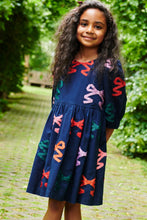 Load image into Gallery viewer, The Girls Multi Bow Applique Brooke Dress from Pink Chicken is a charming navy tiered dress adorned with colorful ribbon bow appliques. Its playful design makes it perfect for any fall occasion, combining comfort and style effortlessly. This dress adds a cheerful touch to your little girl's wardrobe, ensuring she stands out at gatherings and celebrations.