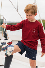 Load image into Gallery viewer, This Boys Harbor Boats Graphic Tee from Saltwater Boys combines comfort and style in a long-sleeve burgundy design perfect for toddlers to tweens. Crafted from soft knit fabric, it features an nautical harbor scene on the back along with a classic SWB logo and pocket on the front, making it an ideal choice for everyday wear or a casual outing. Durable and fashion-forward, this tee ensures your young one looks sharp while staying comfortable throughout the day.