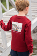 Load image into Gallery viewer, This Boys Harbor Boats Graphic Tee from Saltwater Boys combines comfort and style in a long-sleeve burgundy design perfect for toddlers to tweens. Crafted from soft knit fabric, it features an nautical harbor scene on the back along with a classic SWB logo and pocket on the front, making it an ideal choice for everyday wear or a casual outing. Durable and fashion-forward, this tee ensures your young one looks sharp while staying comfortable throughout the day.