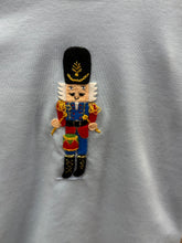 Load image into Gallery viewer, Get your little one holiday-ready with the Boys Nutcracker & Striped Pant Set from Squiggles. This charming ensemble features a light blue long-sleeve tee adorned with a festive Nutcracker applique, paired with coordinating navy and white striped knit pants. Perfectly combining seasonal style with all-day comfort, this set is ideal for family gatherings, holiday photos, or everyday festive fun. Keep your boy cozy and stylish throughout the season with this must-have holiday outfit.