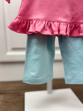 Load image into Gallery viewer, Dress your little one in festive charm with the Girls Applique Nutcracker Ruffle Pant Set by Squiggles. Crafted from soft 100% pima cotton, this set combines comfort with playful style. The bright pink tunic features a delicate pastel Nutcracker applique and a flirty ruffle hem, perfectly complemented by coordinating mint and white striped pants. 