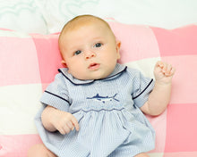 Load image into Gallery viewer, Get ready for a summer of adventure with our Boy's Sailfish Bubble from Cape Point Clothing Co.! This elegant and classic outfit features a checked navy and white design with smocked fish detail and a charming peter pan collar. Perfect for any little gentleman, this bubble is sure to make a splash while keeping your little one looking stylish.