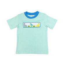 Load image into Gallery viewer, Unleash your little one's adventurous spirit with the Dinosaur Mint Harry’s Play Tee! This vibrant mint-striped knit tee, adorned with playful dinosaur smocking, offers ultimate comfort and breathability, perfect for energetic toddlers. Dress them in style, and watch their imagination roar! Shorts not included.