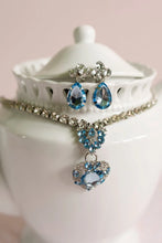 Load image into Gallery viewer, Classic glamour gets a modern twist with The Marilyn 4 Piece set. This bold and beautiful boxed-set includes blue & silver clip-on earrings, a heart-shaped ring, and a coordinating necklace jam-packed with jewels.
- Keep away from fire and Small Parts.
- Batteries not required.
- Recommended Age: 3+