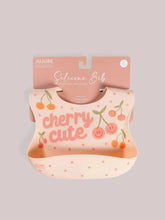 Load image into Gallery viewer, Keep your baby’s clothes clean and dry during feeding time with a nontoxic, food-grade Silicone Bib from JuJuBe × Studio Oh! Made for babies 4 months and older, these bibs feature a deep front pocket to catch messes, and because they are dishwasher-safe, cleanup is fast and easy! Designed to fit comfortably and stay put, each bib features four ouch-free fasteners at the back of the neck strap, so it will stay comfortable as your baby grows.