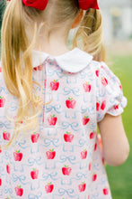 Load image into Gallery viewer, The Apple Blossoms Dress by The Proper Peony is a delightful blend of charm and comfort. Made from soft Pima cotton, it features a whimsical apple and bow print, along with an adorable Peter Pan collar. Perfect for the first day of school, this dress combines style and ease, ensuring your little one feels confident and cute!