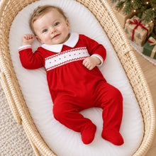Load image into Gallery viewer, A timeless essential with a festive touch, the Miles Smocked Footie by Magnolia Baby blends classic style with everyday comfort. Crafted in a rich red hue, it features an elegant hand-smocked panel with delicate contrast embroidery and a crisp white Peter Pan collar for a polished, traditional look.
