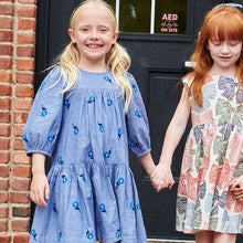Load image into Gallery viewer, The Girls Fiona Dress in Blue Blossom Embroidery features vibrant embroidered blossom patterns that make your girl truly stand out. Designed with comfort and style in mind, this dress allows for easy movement while adding a magical touch to any occasion. Perfect for celebrations or everyday adventures, it brings a charming blend of elegance and playful style to her wardrobe.