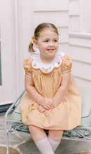 Load image into Gallery viewer, Celebrate the season in the Luciana Loop Pumpkin Dress by The Proper Peony. This charming gingham orange and white dress features a delicate scalloped collar with hand-embroidered pumpkin details, adding a touch of whimsy to your child's fall wardrobe. Perfect for autumn gatherings, its simple yet elegant design ensures your little one looks festive and stylish with ease.