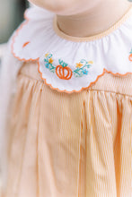 Load image into Gallery viewer, Celebrate the season in the Luciana Loop Pumpkin Dress by The Proper Peony. This charming gingham orange and white dress features a delicate scalloped collar with hand-embroidered pumpkin details, adding a touch of whimsy to your child's fall wardrobe. Perfect for autumn gatherings, its simple yet elegant design ensures your little one looks festive and stylish with ease.