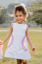 Load image into Gallery viewer, This adorable Rainbow Skye Dress from Zuccini Kids for toddler girls features mini light blue seersucker, vibrant rainbow appliqués on the pockets, and a colorful cross back with bow design. Perfect for any occasion, this dress will have your little one looking cute and stylish while staying comfortable.