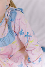 Load image into Gallery viewer, Dress your little one in the Ribbon Party Long Sleeve Dress from The Proper Peony, designed for both comfort and charm. Its soft knit fabric ensures ease of movement and cozy wear, while the playful bow pattern and ruffle bib collar add a sweet, elegant touch. Perfect for special occasions or everyday fun, this pink dress combines style and softness to keep your toddler happy and looking adorable.