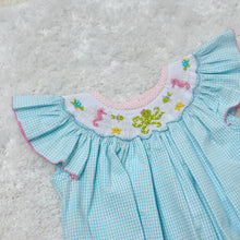 Load image into Gallery viewer, Dive into summer with the Under The Sea Billie Bishop Bubble from Zuccini Kids. This charming bubble features a refreshing teal and white check pattern complemented by an elegant bishop smocked neckline. Adorned with delightful embroidered sea animals, this outfit transforms everyday play into magical underwater adventures. Perfect for beach outings, summer parties, or simply making a splash at daycare!