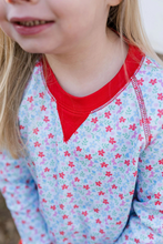 Load image into Gallery viewer, The Girls Sidney Sweatshirt in Full Bloom combines classic comfort with vibrant style. Its light fabric ensures a cozy fit, while the playful blue and red floral print adds a fresh, cheerful touch. Accented with a striking red collar and details, this sweatshirt brightens any outfit. For a coordinated look that’s perfect for play or casual days, pair it with the Full Bloom Red Scallop Leggings. Elevate your little girl's wardrobe with this charming and versatile set today.