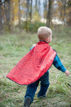 Load image into Gallery viewer, Every hero needs a cape! The Colour-A-Cape Spider Superhero is the perfect addition to your crime-fighter's wardrobe. Save the day or defeat monsters in the backyard with personalized style and flair! Includes 6 markers. This cape is also reversible with a red spider printed satin on the other side.
