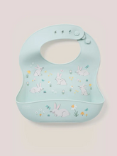 Load image into Gallery viewer, Keep your baby’s clothes clean and dry during feeding time with a nontoxic, food-grade Silicone Bib from JuJuBe × Studio Oh! Made for babies 4 months and older, these bibs feature a deep front pocket to catch messes, and because they are dishwasher-safe, cleanup is fast and easy! Designed to fit comfortably and stay put, each bib features four ouch-free fasteners at the back of the neck strap, so it will stay comfortable as your baby grows. The Silicone Bib is BPA-free, PVC-free, phthalate-free, and lead-fr