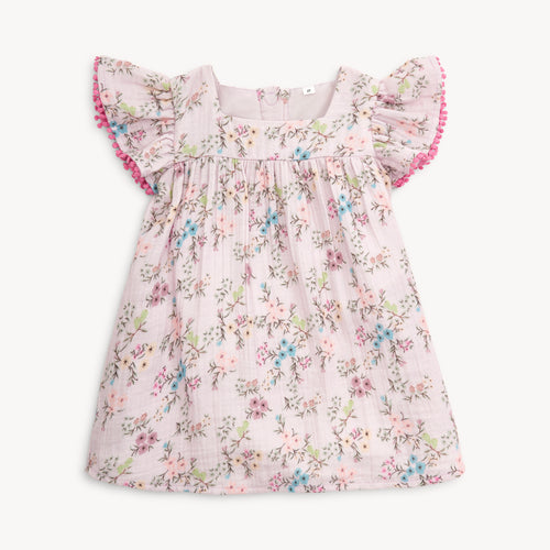 Dress your toddler in comfort and style with the Emily Cotton Dress from Magnetic Me. Made from soft muslin material, this dress features a beautiful lavender and floral design. Sweet flutter sleeves and back magnetic closure makes this an easy and off dress! Perfectly matching the Emily Footie Pajamas for infants, your little one will look adorable and feel cozy all day long.