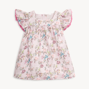 Dress your toddler in comfort and style with the Emily Cotton Dress from Magnetic Me. Made from soft muslin material, this dress features a beautiful lavender and floral design. Sweet flutter sleeves and back magnetic closure makes this an easy and off dress! Perfectly matching the Emily Footie Pajamas for infants, your little one will look adorable and feel cozy all day long.