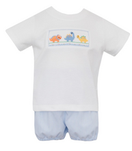 Load image into Gallery viewer, Experience the fierce fun of our Boy&#39;s Dino Knit Short Set by Petit Bebe! The soft white knit shirt features adorable dinosaur stitching, while the blue tiny stripe shorts add a playful touch. Perfect for any young explorer&#39;s daily adventures.
