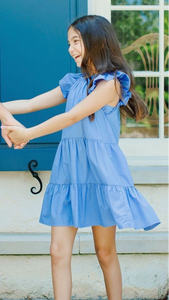 Transform your tween's spring wardrobe with our Layla Dress in Lapis Blue from Pleat! Featuring a flattering ruffle cap sleeves and a tiered skirt, this dress exudes charm and femininity. Elevate her style with this must-have piece!