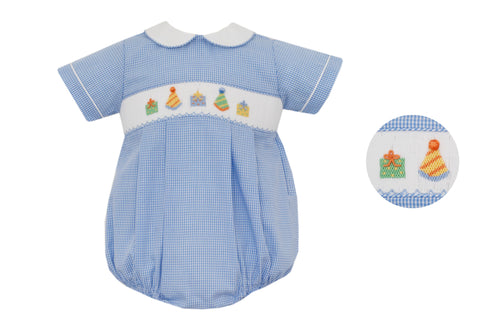 Celebrate your little one’s special day in style with the Boy's Blue Gingham Birthday Smocked Bubble by Petit Bebe. This charming outfit showcases a blue and white gingham design, adorned with a delicate smocking and embroidered birthday hats and gifts detail. Ideal for making your infant boy's birthday truly unforgettable!