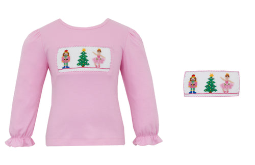 Get ready to dance into the holiday season with our Girl’s Smocked Nutcracker Tee by Anavini! This pink knit top features intricate nutcracker themed smocking, making it the perfect festive addition to your little one's wardrobe. Spread holiday cheer with this adorable and stylish tee!