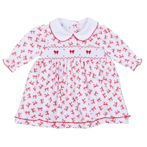 Dress your little one in timeless elegance with the Infant Girls Scarlett Bows Smocked Dress from Magnolia Baby. Crafted from 100% soft, breathable Pima cotton, this dress ensures all-day comfort for delicate skin. Its charming red bows print adds a playful yet refined touch, while the delicate smocked chest and red picot trim on the collar and cuffs offer classic handcrafted details. The ruffled skirt completes the look with sweet sophistication, and the included diaper cover makes it perfect for any speci