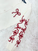 Load image into Gallery viewer, Elevate your little girl&#39;s wardrobe with our Girl&#39;s Red Bow Cardigan by Duffield Lane! This charming white knit cardigan features darling bows on both the sleeves and chest, adding a touch of sweetness to any outfit. Perfect for any occasion, this cardigan will keep her warm and stylish.
