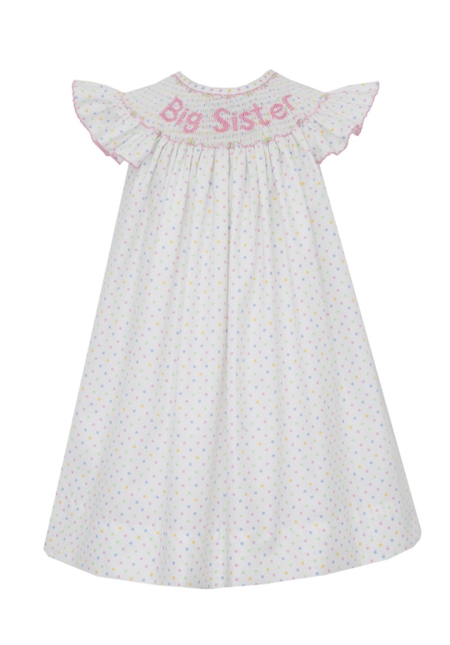 Get your little one ready for her role as Big Sister with this elegant and sweet Bishop dress by Anavini. The white polka dotted smocked dress is adorned with delicate pink embroidery that reads 