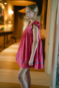 Get ready to add some playful charm to your little girl's wardrobe with the Girls Ellen Dress in Red &amp; Purple! Made with a mix of cotton and viscose, this dress is not only comfortable but also easy to care for. The delicate flutter sleeves and purple trim add a touch of whimsy, making it perfect for any occasion. Machine wash cold and hang to dry for hassle-free maintenance.