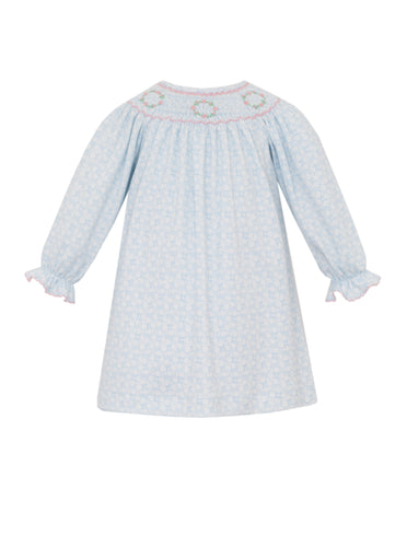 Introduce your little one to timeless elegance with this charming blue floral dress from Petit Bebe. Crafted from luxuriously soft pima cotton, this long-sleeve bishop dress features a delicate smocked neckline adorned with hand-embroidered floral details that add a touch of artisanal sophistication.
