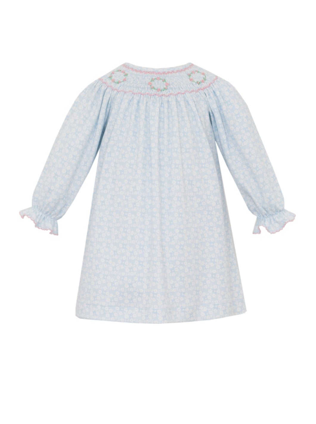 Introduce your little one to timeless elegance with this charming blue floral dress from Petit Bebe. Crafted from luxuriously soft pima cotton, this long-sleeve bishop dress features a delicate smocked neckline adorned with hand-embroidered floral details that add a touch of artisanal sophistication.