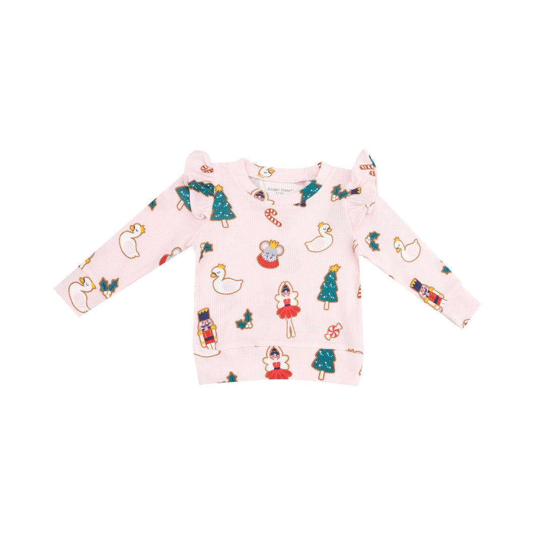 Introducing our Nutcracker Christmas Cookies Ruffle Sweatshirt! Made with cozy waffle/thermal material from Angel Dear, this sweatshirt is perfect for your little girl. Keep her warm and stylish this holiday season with our adorable Nutcracker design. Available in pink and white!