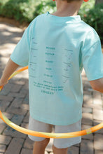 Load image into Gallery viewer, Elevate your young golfer's style with the Boys Golf Club Tee by J Bailey! This vibrant aqua green knit tee, adorned with a charming golf club design on the back, is perfect for spring outings. It combines comfort and fun, making every swing even more exciting!
