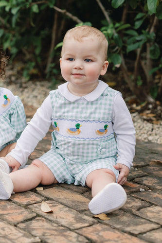 Dress your little one in timeless charm with the Boys Smocked Henry Mallard Jon Jon by Shop Teeta. Featuring a classic green and white gingham check, this Jon Jon is adorned with delicate smocking and detailed embroidered mallard ducks, adding a sweet and playful touch. Perfect for coordinated family moments, it also pairs beautifully with matching sibling styles. This piece combines traditional design with exceptional craftsmanship, making it an irresistible choice for any special occasion or everyday deli
