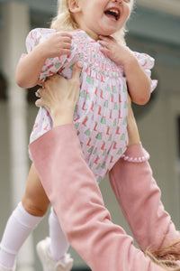 Celebrate the festive season in style with the Girls Hallie Cowboy Christmas Bubble from Shop Teeta. This charming bubble outfit features a playful Christmas and cowboy boots print that brings a touch of whimsy to your little one’s wardrobe. The smocked neckline adds a classic, comfortable fit, making it perfect for holiday gatherings and everyday fun.&nbsp;