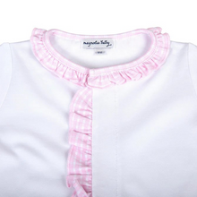 Load image into Gallery viewer, Wrap your little one in gentle comfort with the Magnolia Baby New Beginnings Ruffle Footie in Pink. Crafted from luxurious Pima Cotton, this soft white footie features delicate pink minicheck trim along the neckline, placket, and cuffs. Designed for ultimate coziness and ease, it provides full coverage to keep tiny toes warm and secure.
