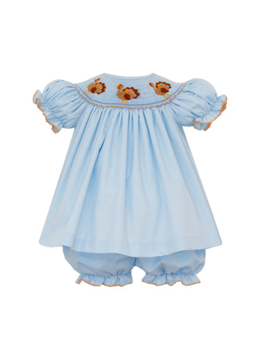 Celebrate Thanksgiving in timeless style with this Infant Girls Smocked Turkey Bishop Bloomer Set. Crafted from soft blue twill, it features delicate hand-embroidered turkeys on expertly smocked detailing, making it a charming choice for holiday gatherings. Perfect for creating unforgettable sibling photos, coordinating matching outfits are available to complete the festive look.