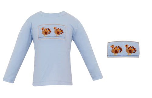 Dress your little one in charming style with the Boys Smocked Turkey Pant Set from Petit Bebe. This adorable outfit features a light blue tee with delicate smocking and hand-embroidered turkeys, offering a unique, handcrafted touch. The coordinating khaki and white mini-checked pull-on twill pants provide comfort and easy wear. Perfect for family gatherings, this set also comes with matching sibling options for coordinated looks that make lasting memories. 