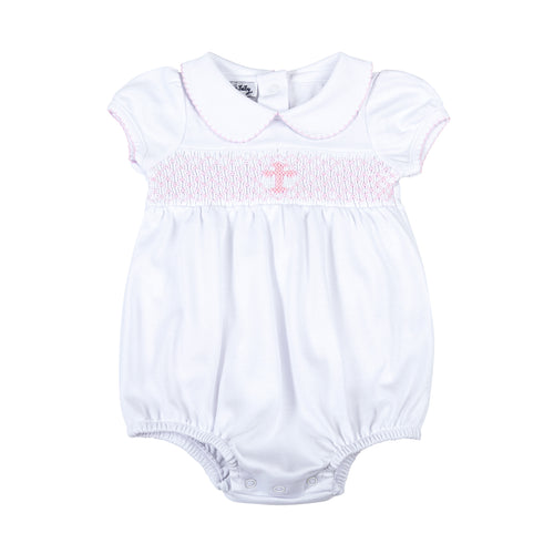 Wrap your little one in love and blessings with our Girls Pink Smocked Blessed Bubble. Made from soft, high-quality fabric, this bubble features delicate pink smocking and a beautiful cross detail, perfect for any special Baptism and religious occasion. With its classic peter pan collar, your little girl will look and feel blessed.