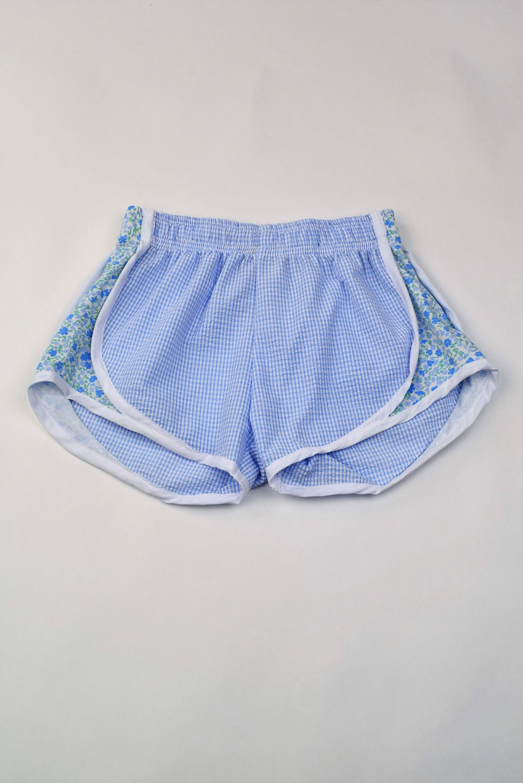 Upgrade your little girl's athletic wardrobe with our Blue Gingham & Floral Track Shorts from Funtasia Too! These stylish blue shorts feature a beautiful floral accent on the sides, adding a touch of feminine charm to her sporty look. Perfect for pairing with the Angel Tee!