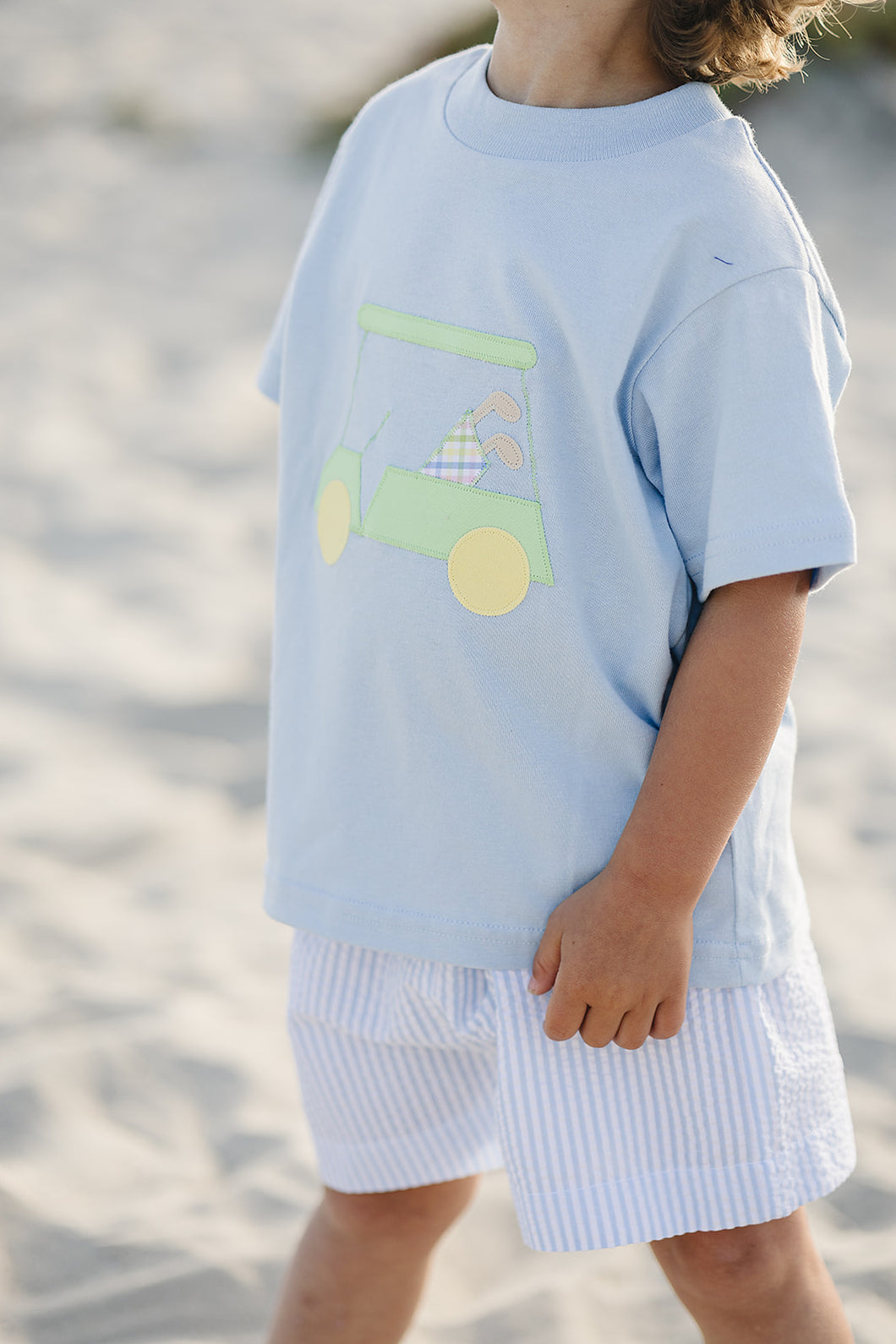 This toddler boys Golf Cart Applique Tee from Funtasia Too! will have your little one looking stylish on the green. Featuring a cool blue color and adorable golf cart applique, this tee is perfect for any mini golfer. Pair with the matching blue and white striped shorts for a classic and adorable look.