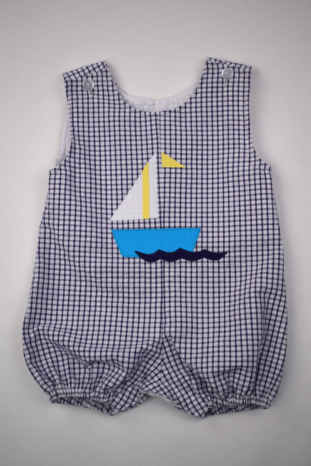 Sail away in style with our Sailboat Gingham Bubble! Designed for toddler boys, this bubble features a charming navy and white gingham print with a playful sailboat applique. Perfect for any summer adventure, this bubble will keep your little one cool and comfortable.