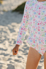 Load image into Gallery viewer, Get ready to make a splash with our Floral Rash Guard One Piece Swimsuit! Designed by Funtasia Too, this adorable swimsuit features a cute pink, blue and green floral design on a white background. The rash guard style and ruffle waist accent make it both stylish and practical for your little one. Dive in now!
