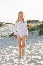Load image into Gallery viewer, Get ready to make a splash with our Floral Rash Guard One Piece Swimsuit! Designed by Funtasia Too, this adorable swimsuit features a cute pink, blue and green floral design on a white background. The rash guard style and ruffle waist accent make it both stylish and practical for your little one. Dive in now!
