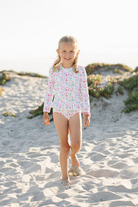 Get ready to make a splash with our Floral Rash Guard One Piece Swimsuit! Designed by Funtasia Too, this adorable swimsuit features a cute pink, blue and green floral design on a white background. The rash guard style and ruffle waist accent make it both stylish and practical for your little one. Dive in now!