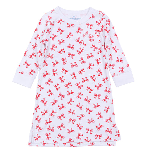 The Girls Scarlett Bows Long Sleeve Nightdress by Magnolia Baby offers cozy comfort with a charming holiday touch. Featuring a soft white fabric adorned with printed playful red bows, this knee-length nightgown keeps your little girl warm and stylish through every night. Its long sleeves provide extra warmth, making it perfect for festive celebrations or everyday bedtime. 