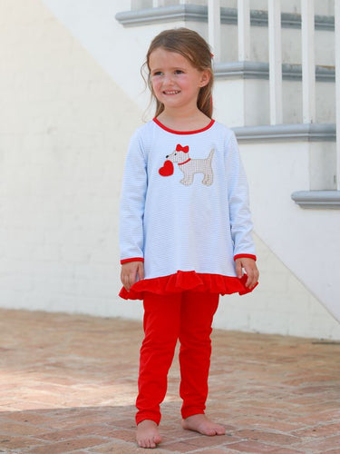 Introducing the Girls Puppy Love Ruffle Pants Set by Trotter Street Kids! This charming set pairs a light blue ruffled striped shirt with an adorable puppy appliqué holding a heart, with vibrant red pants. Perfect for little girls who love puppies and ruffles!